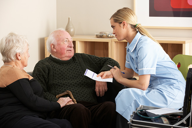 A female nurse talking to a man and his partner