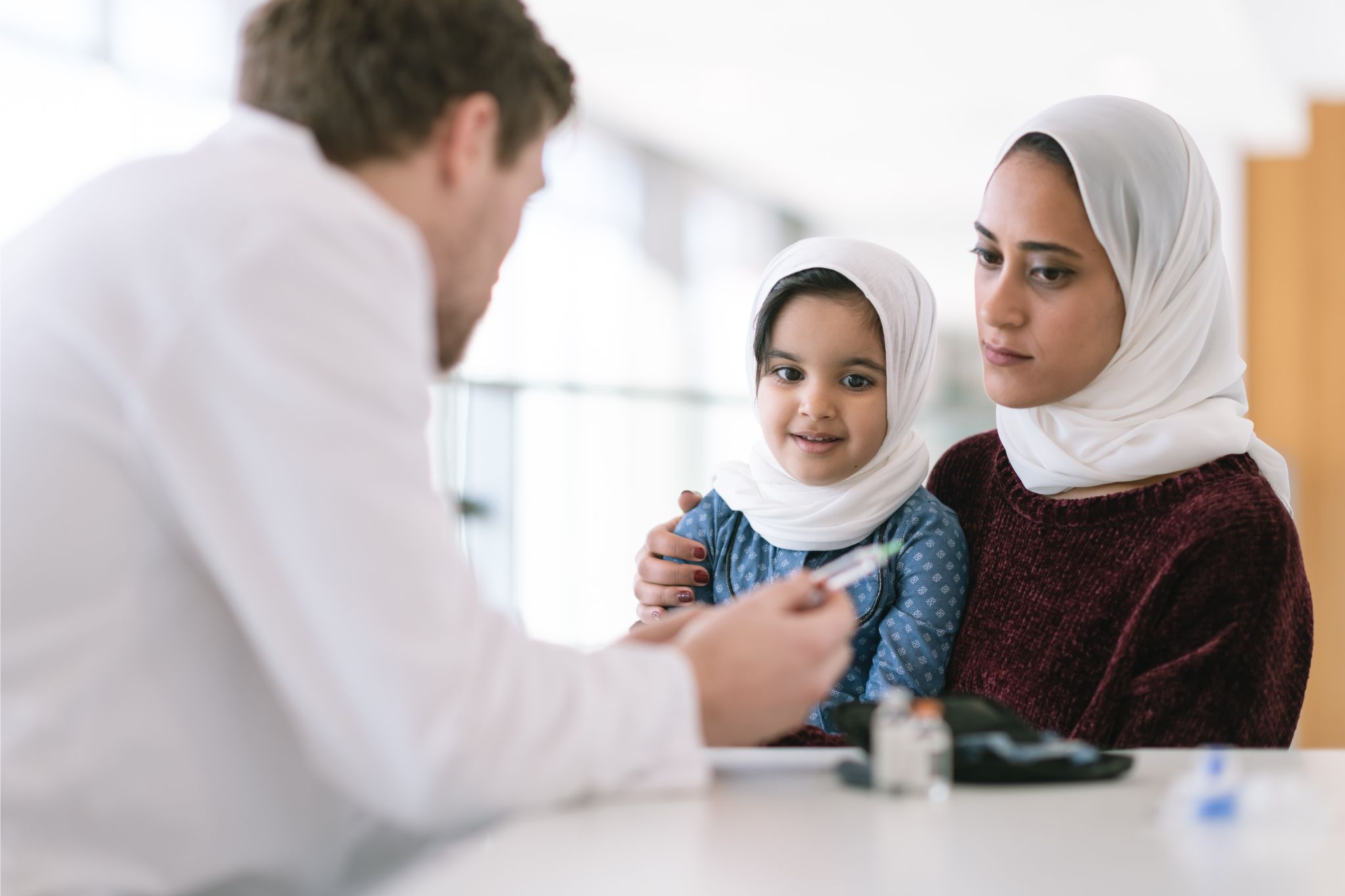 Woman and child speaking with a male professional